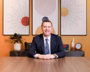 man smiling sitting at desk 